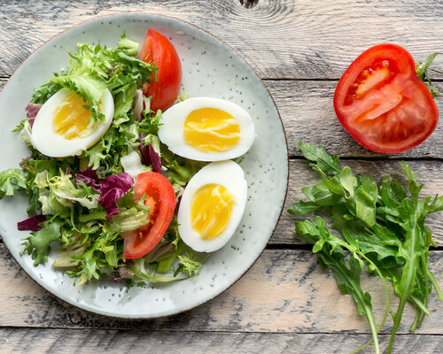 Hamburger met ui, gebakken aardappel en gemengde salade