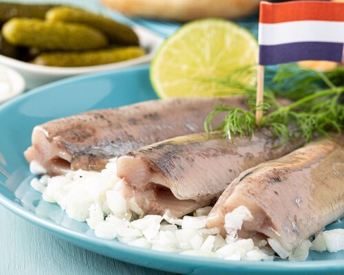 Hollandse nieuwe haring op een wit puntje met apart verpakt uitjes & zuur