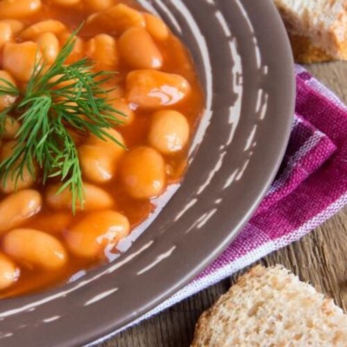 Boomstammetje met witte bonen in tomatensaus en gekookte aardappels