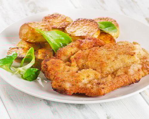 Zigeunerschnitzel met zigeunersaus, doperwten en gebakken aardappel