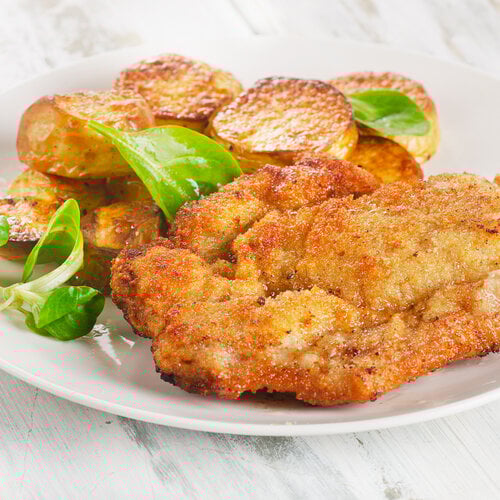 Zigeunerschnitzel met zigeunersaus, doperwten en gebakken aardappel