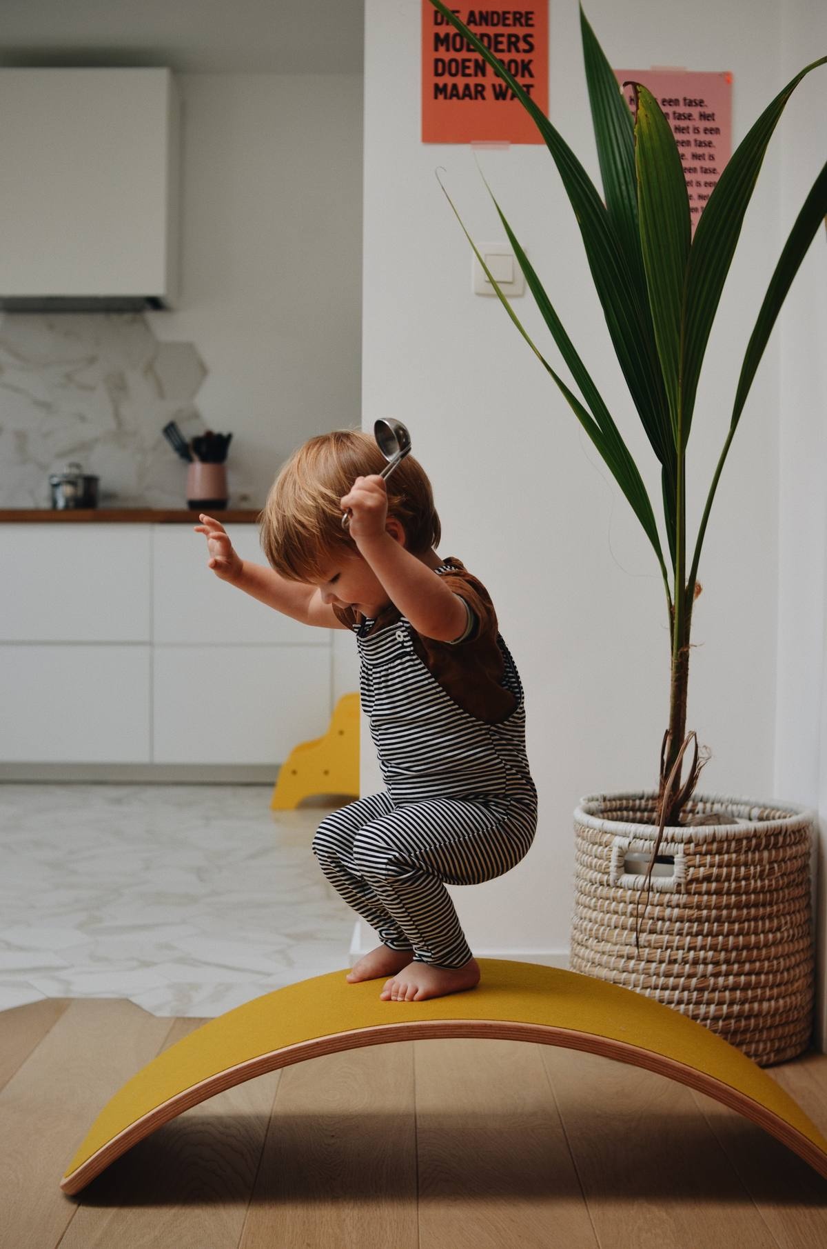 Toddler balancing freely on a yellow Wobbel balance board