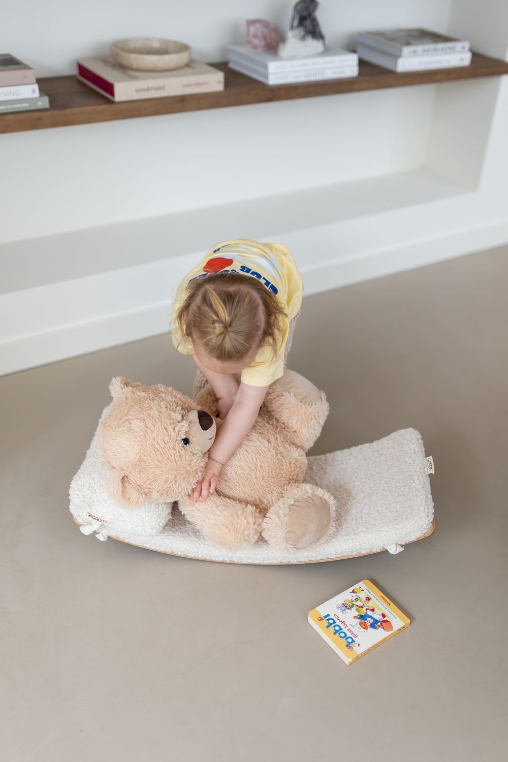 Peuter legt een beer op de Wobbel Starter met pillow