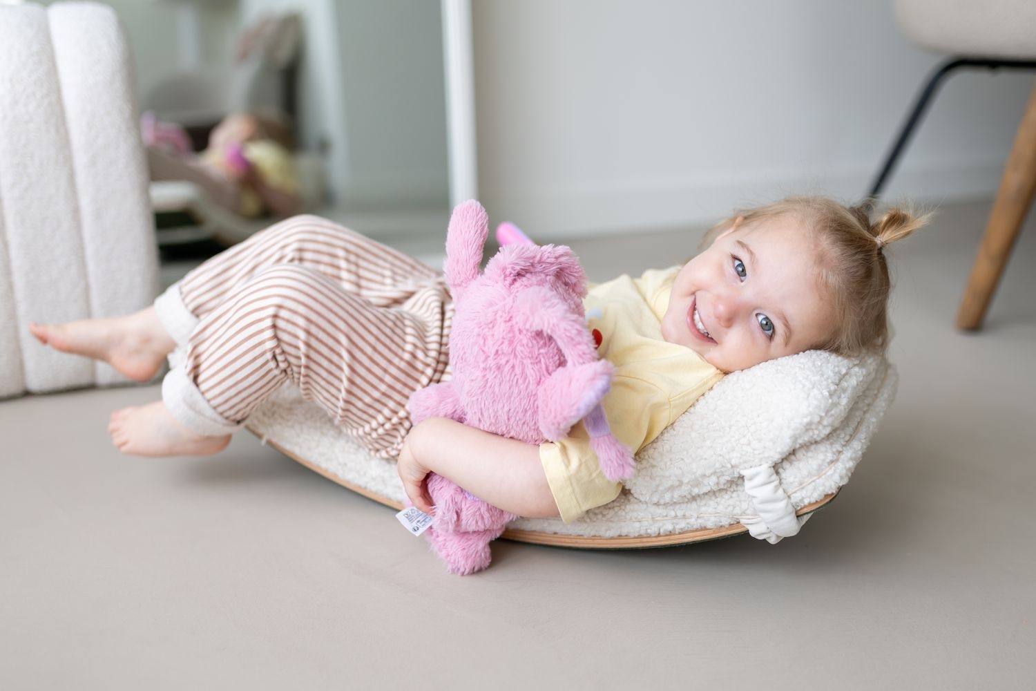 Peuter ligt met knuffel op de Wobbel Starter met pillow
