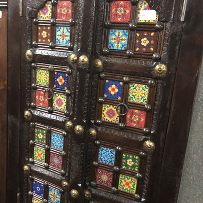 Kleurrijke tegeltjes met houtsnijwerk in oosterse kast verwerkt