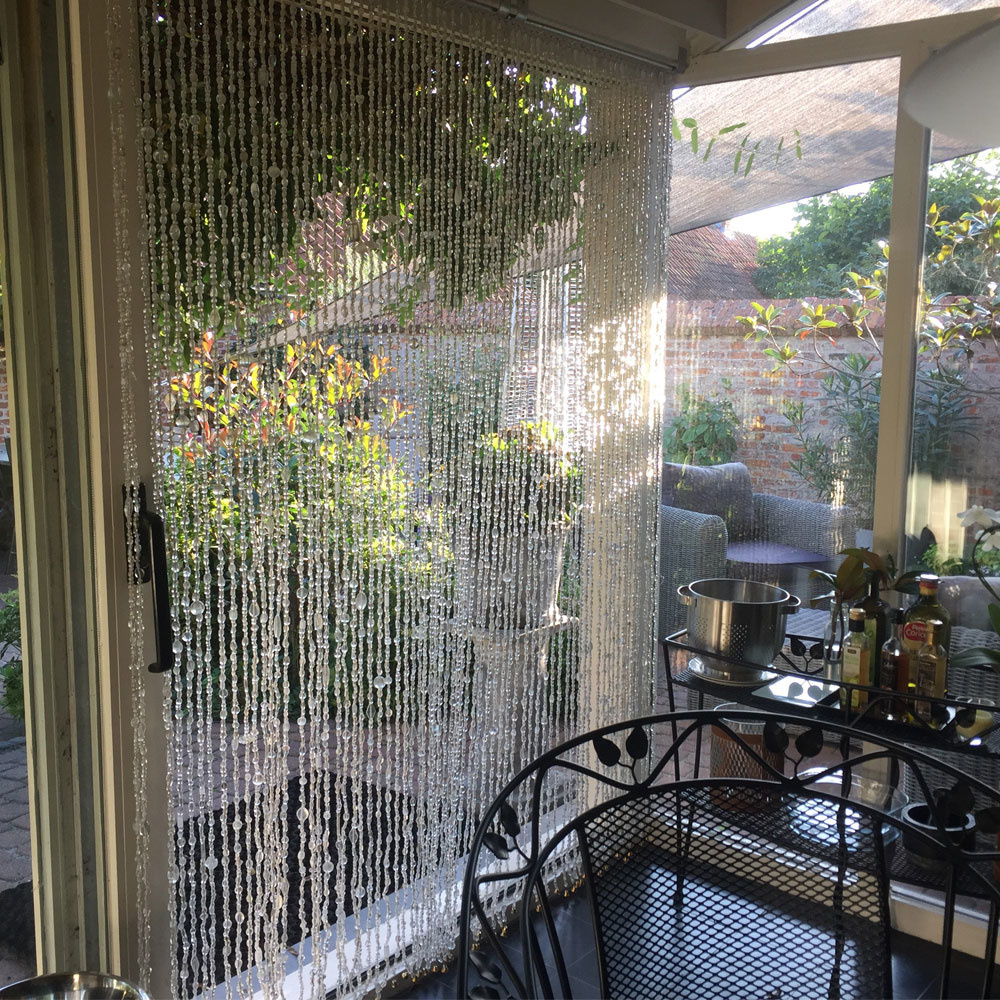 Vliegengordijn van glaskralen in deurpost