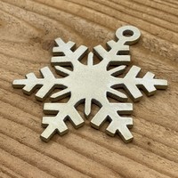 Leuke vervanger van de traditionele kerstbal is deze gouden uitgesneden sneeuvlok.