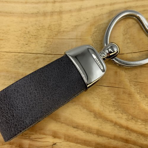 Grijze sleutelhanger met hart vormige sleutelring. 