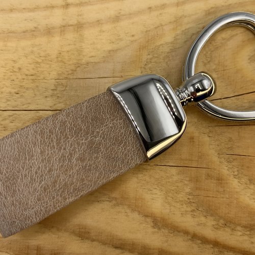 Taupe sleutelhanger met hart vormige sleutelring. 