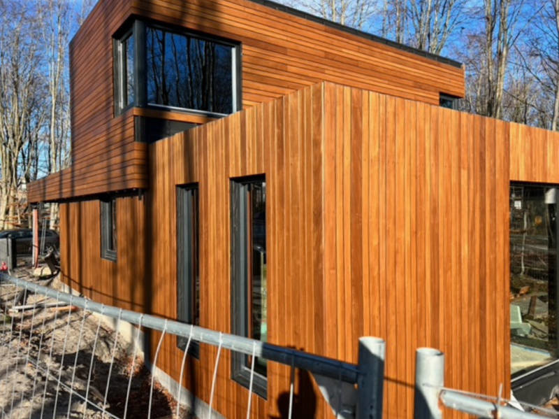 Ein Holzhaus streichen, bevor es fertig ist