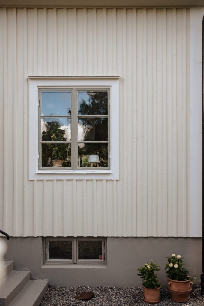 Detail einer weiß gestrichenen Douglasie-Profilholzfassade mit Holzfenster, die Holzstruktur bleibt sichtbar