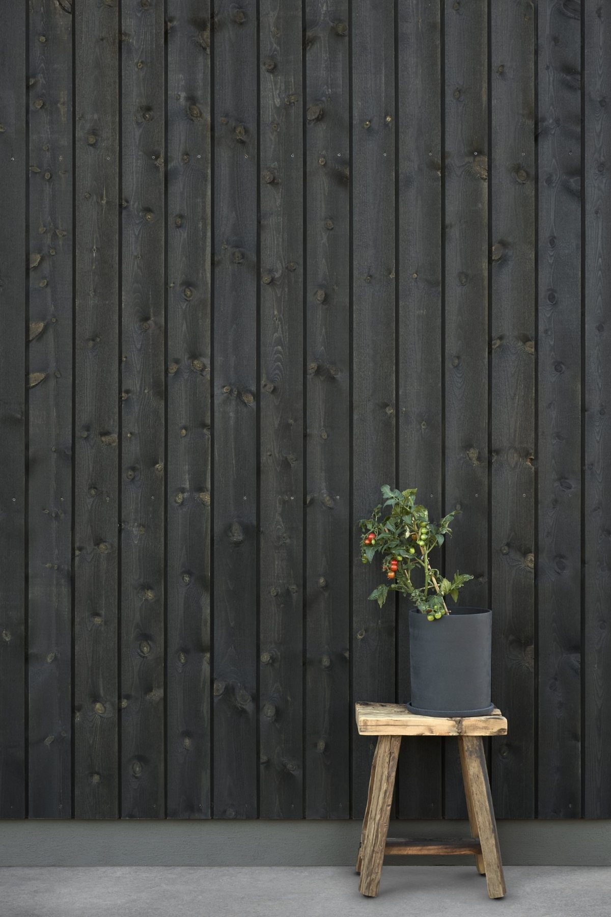 Schwarze Holzfassade mit Jotun Trebitt Woodcare 9809 Night Black, die Maserung bleibt sichtbar