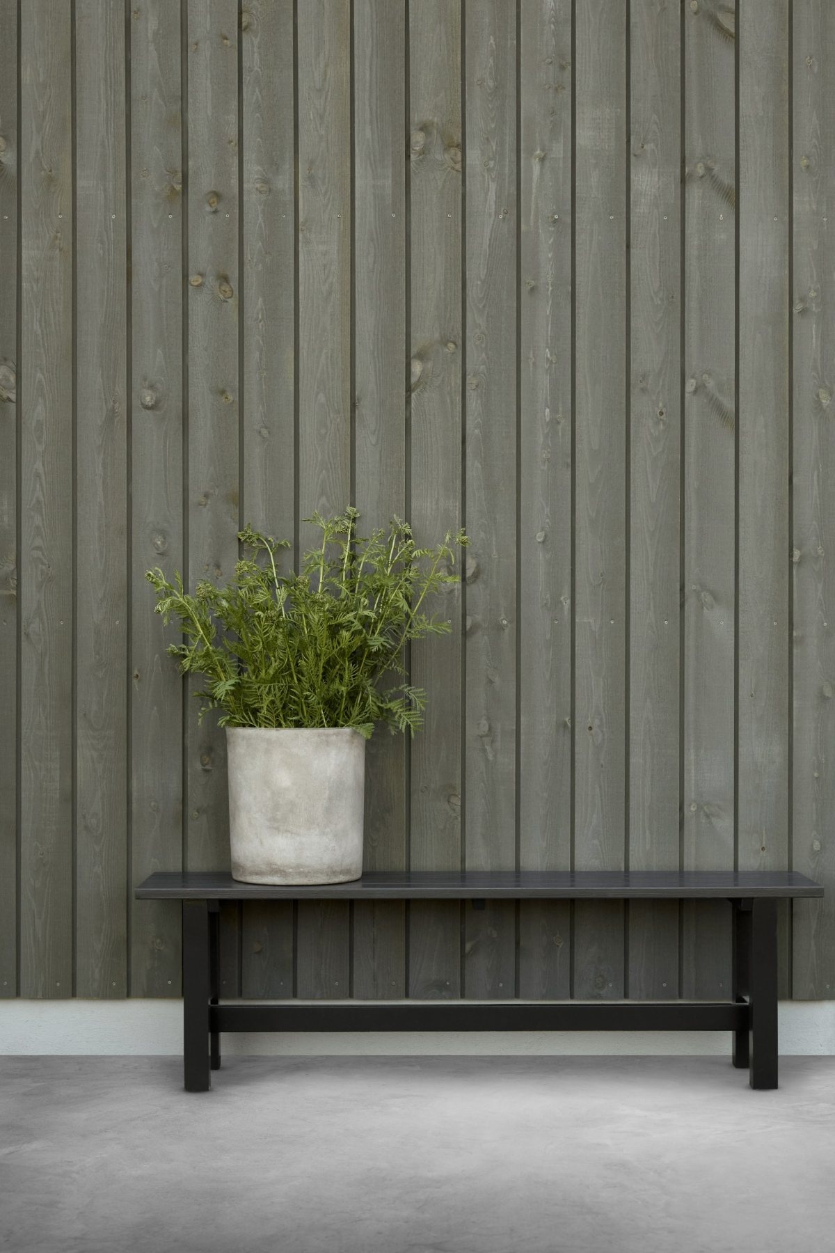 Holzfassade in Jotun 9814 Gorgeous Grey Imprägnierte Holzfassade mit Jotun Trebitt Woodcare in 9814 Gorgeous Grey, graue senkrechte Schalung mit Beistelltisch