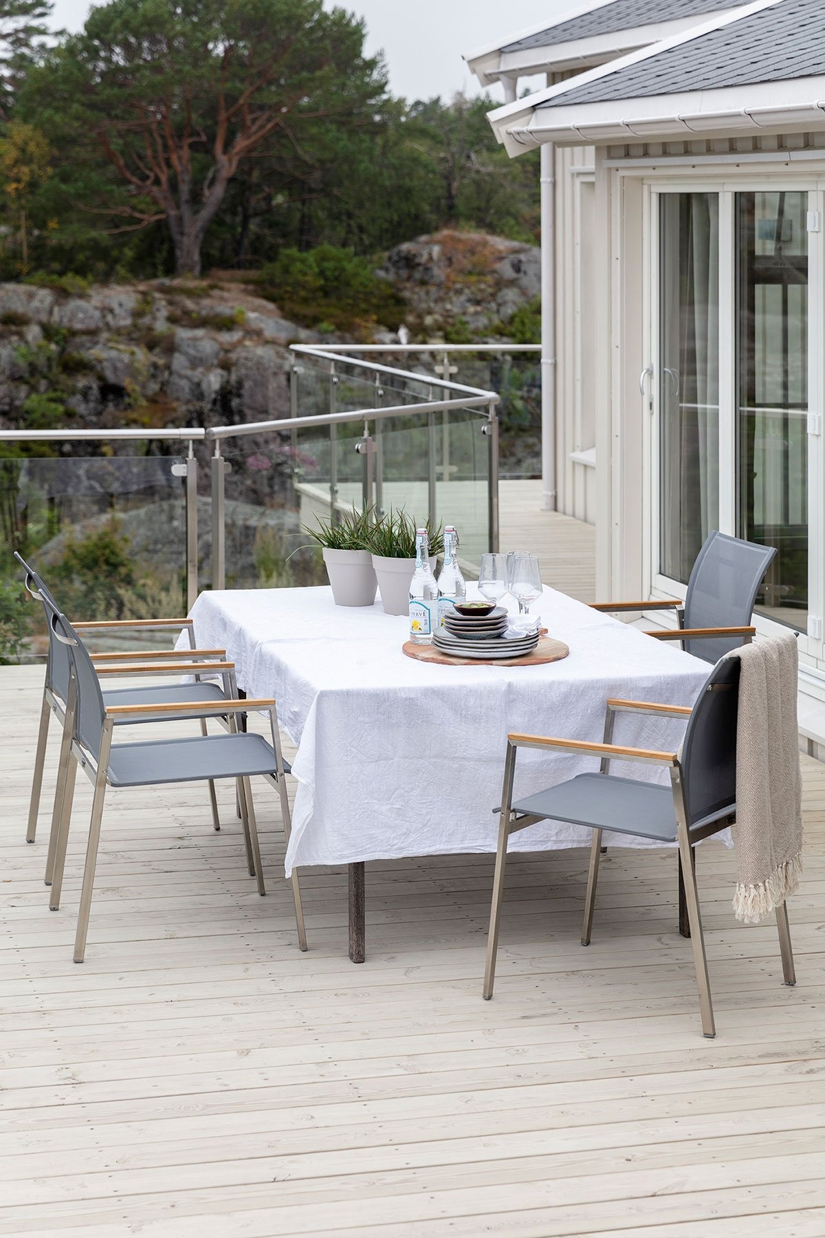 Holzterrasse in Jotun 9072 Naturgrå Holzterrasse mit Jotun Demidekk Terrasslasyr in 9072 Naturgrå, hellgraue Terrassendielen mit gedecktem Esstisch