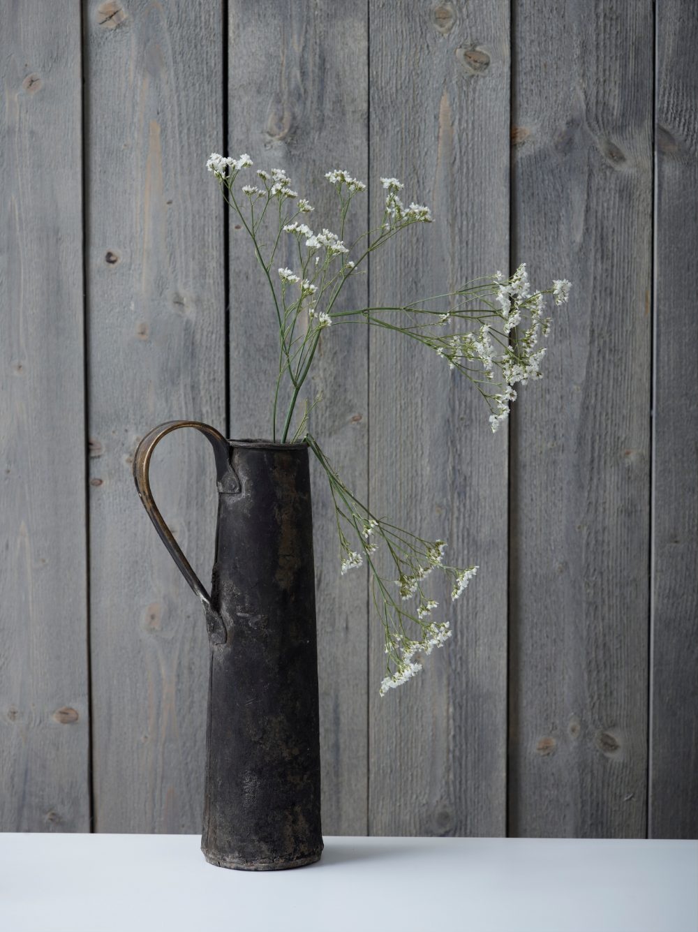 Paneelwand in Jotun 90022 Dämpad Grå Holzwand innen mit Jotun Panellakk in 90022 Dämpad Grå, grau gebeizte Paneelwand mit Vase und Blumen