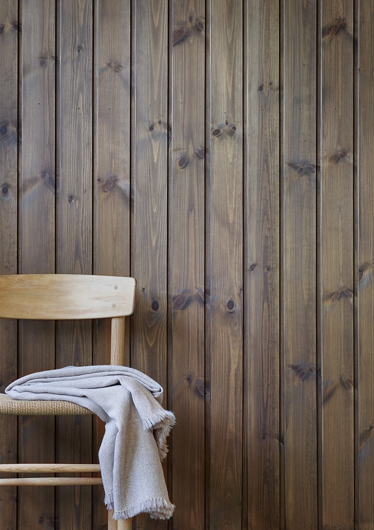 Paneelwand in Jotun 90024 Djup Brun Holzwand innen mit Jotun Panellakk in 90024 Djup Brun, tiefbraun gebeizte Paneelwand mit Holzstuhl