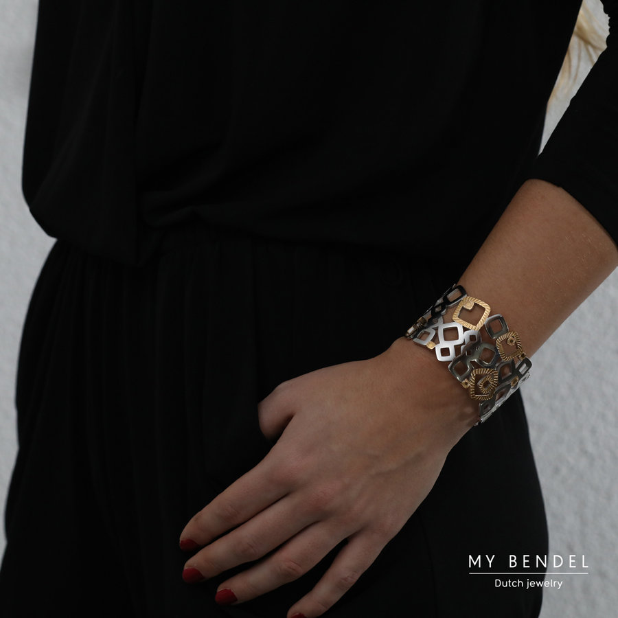 My Bendel Chique bangle met bicolor vierkanten. Speels en asymmetrisch design. Stijlvolle open bewerking. Perfect voor een krachtige look. # HO1001