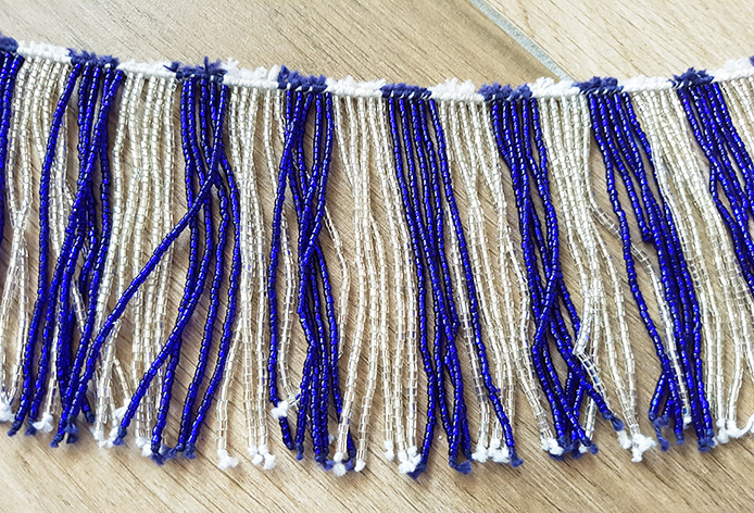 Beaded strip with blue/silver or gold strands with many beads
