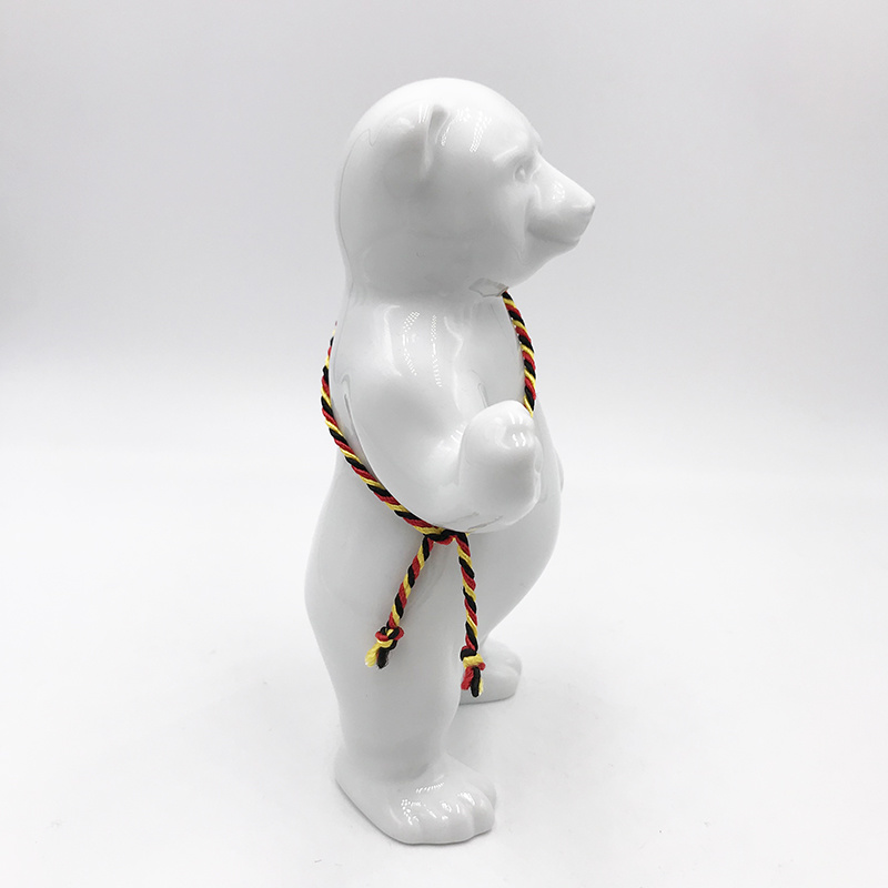 ART-DOMINO® BY SABINE WELZ Porcelain bear from Berlin - With black, red and yellow sash