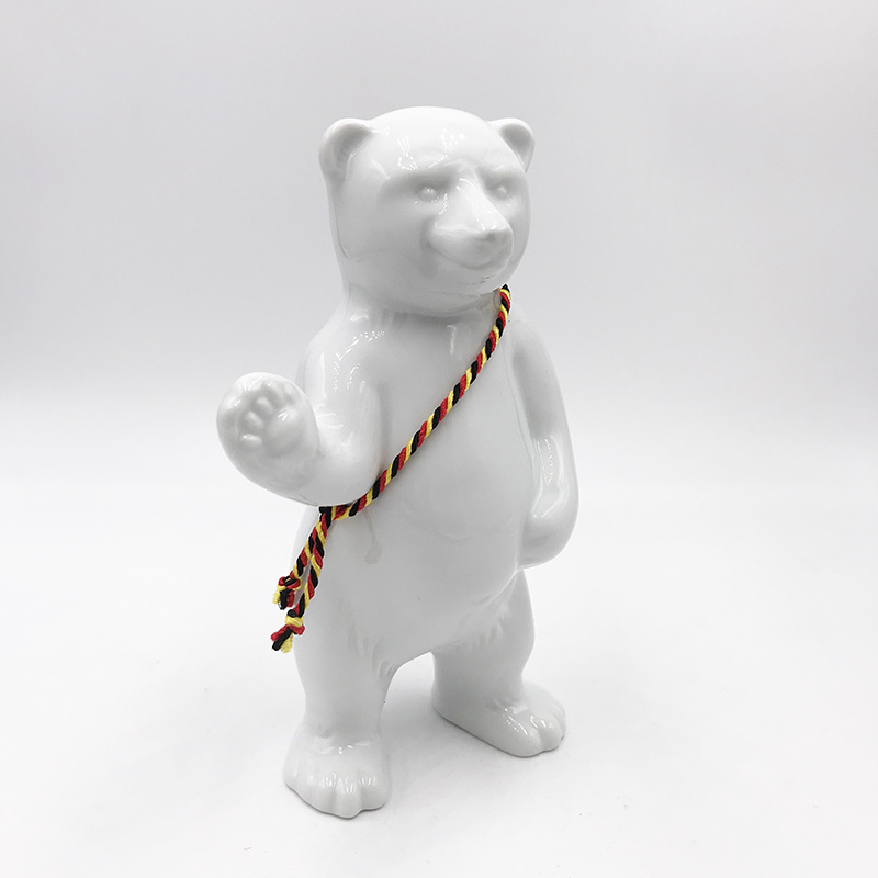 ART-DOMINO® BY SABINE WELZ Porcelain bear from Berlin - With black, red and yellow sash