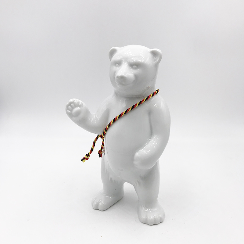 ART-DOMINO® BY SABINE WELZ Porcelain bear from Berlin - With black, red and yellow sash