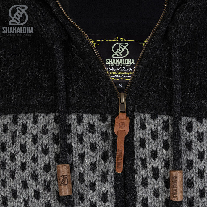Shakaloha M Tundra Antraciet/Grijs – wollen herenvest met polyester fleece, YKK frontzip, afritsbare capuchon met anti-open knopje, kangoeroezak met fleecevoering + interne borstzak met rits, 2 wollen trekkoorden met houten ringen gegraveerd met Shakaloha‑logo, reg