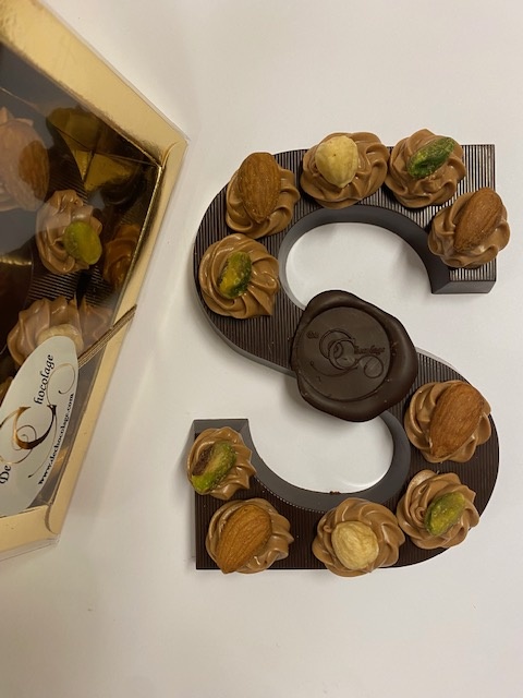 Dark chocolate letter with hazelnut tufts and nuts
