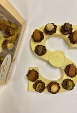 White chocolate letter with hazelnut tufts and nuts
