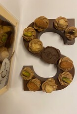 Milk chocolate letter with hazelnut tufts and nuts