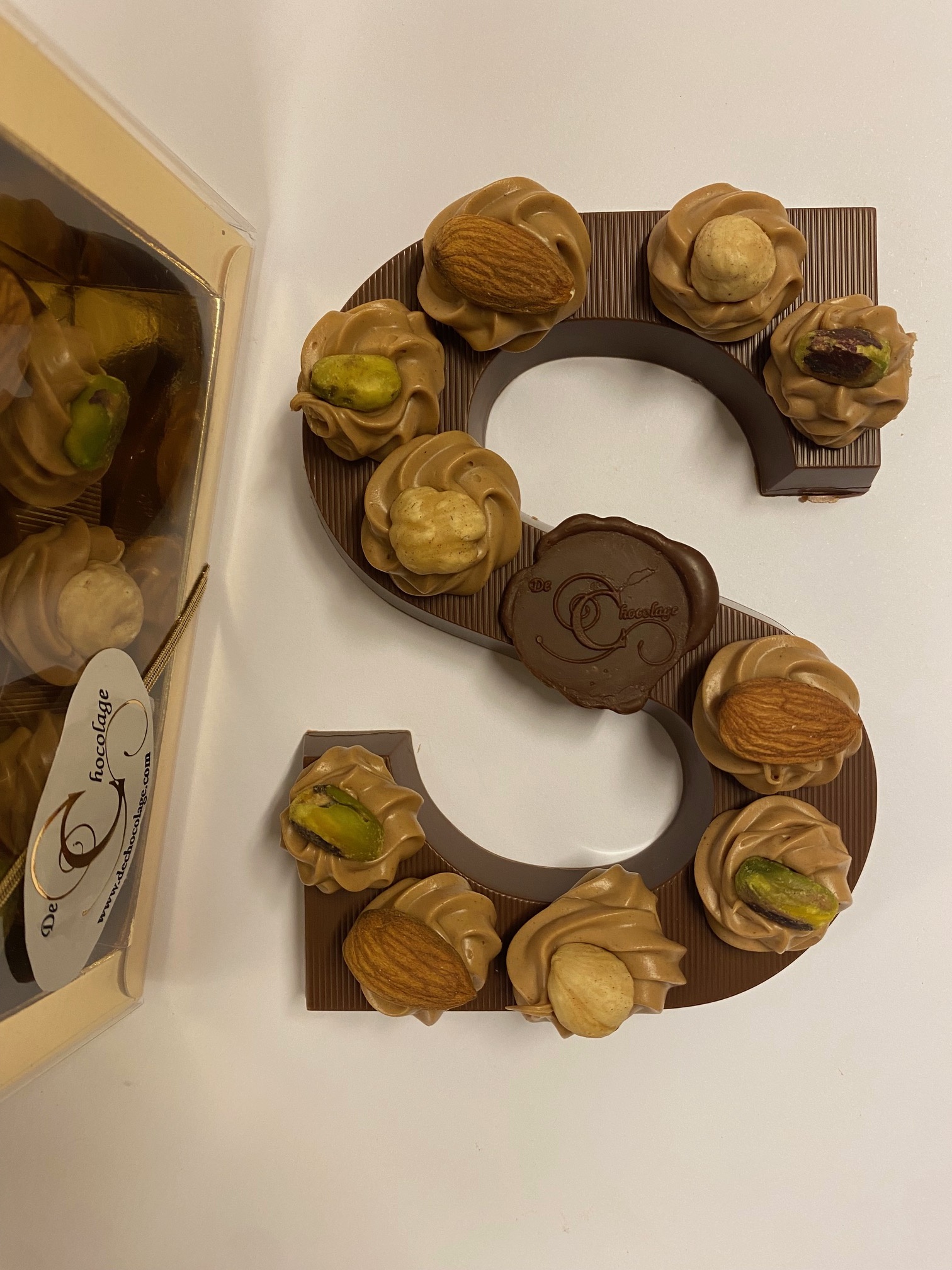 Milk chocolate letter with hazelnut tufts and nuts