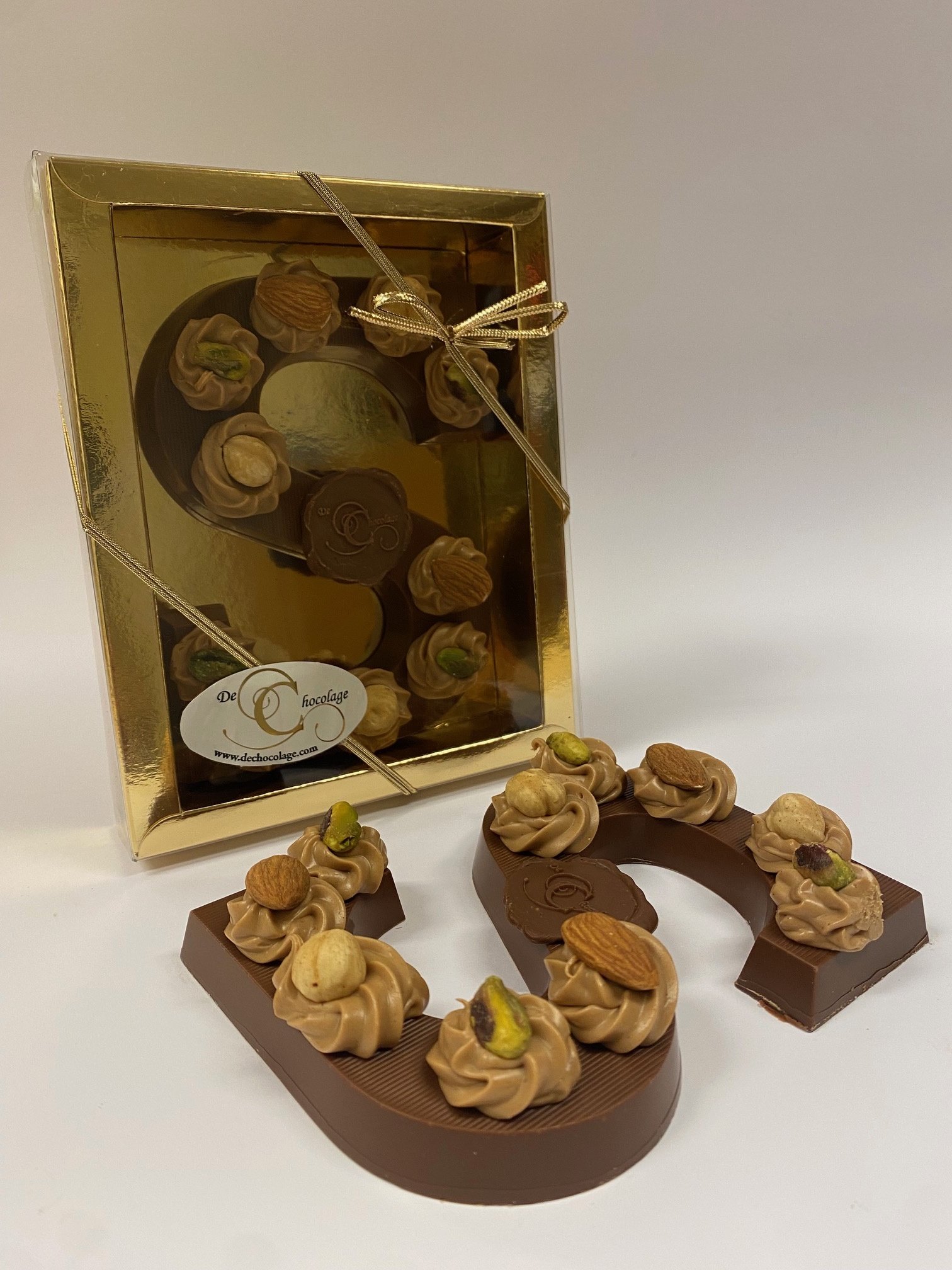 Gevulde melkchocolade letter met hazelnoot toefjes en noten