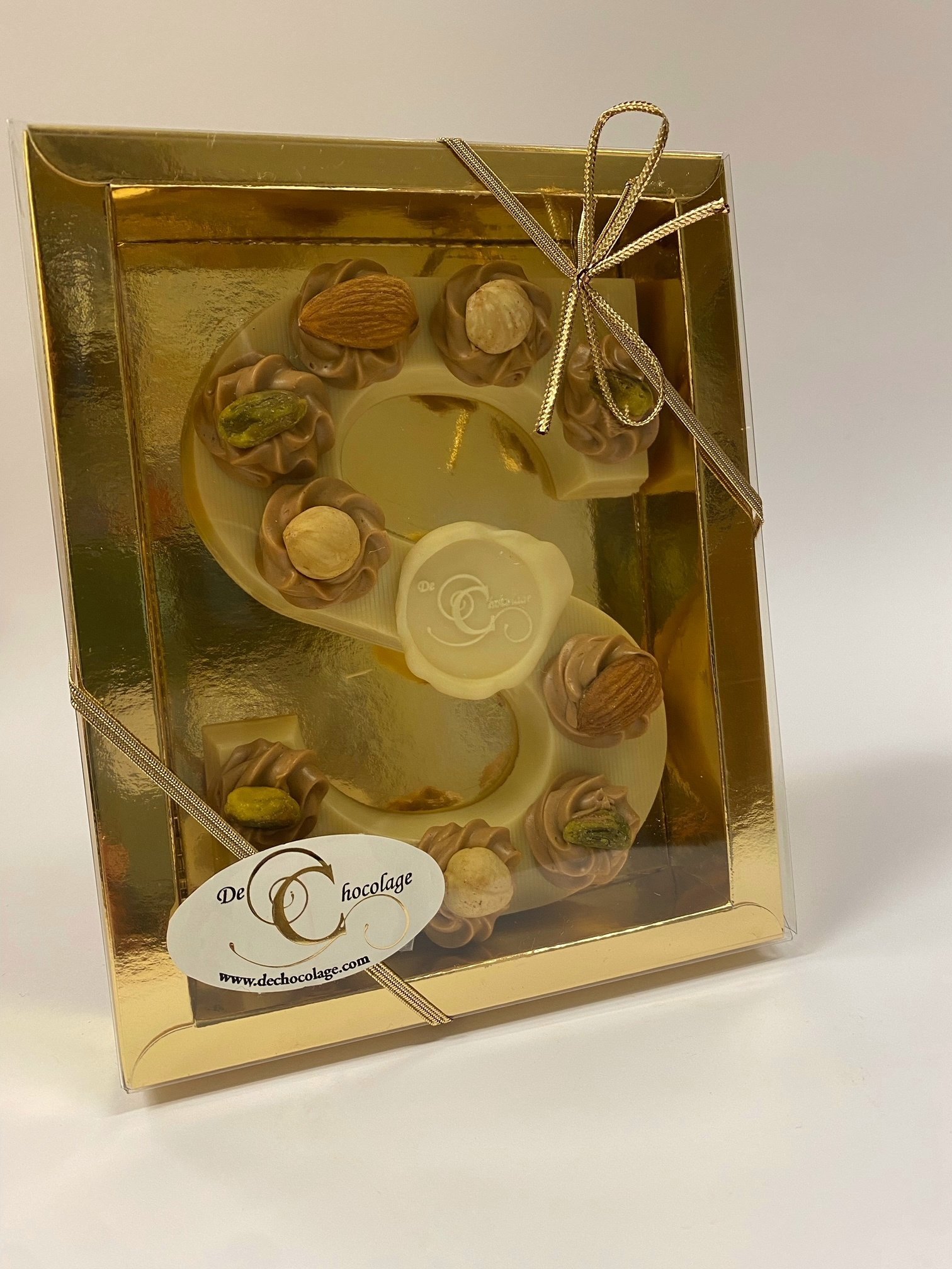 Gevulde witte chocoladeletter met hazelnoot toefjes en noten