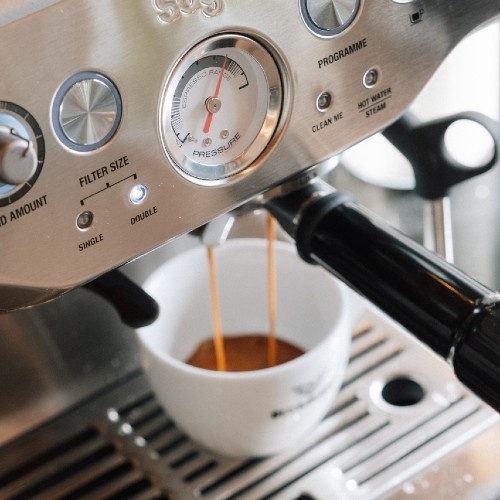 Sage Barista Pro in Black Stainless op een aanrecht, met een Blommers-kop en een melkkan