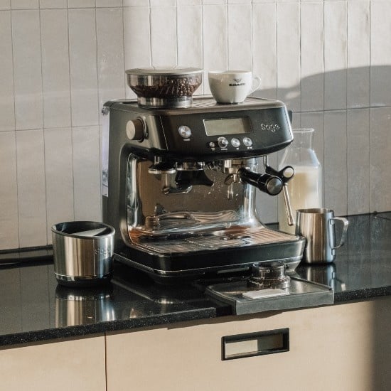 Sage Barista Pro in Black Stainless op een aanrecht, met een Blommers-kop en een melkkan