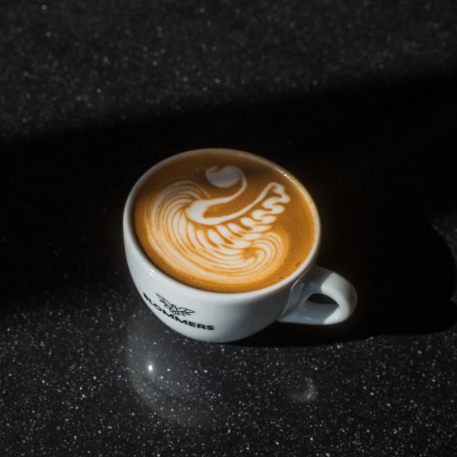 Cappuccino met latte art in een Blommers-kop