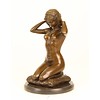 Bronze sculpture of a naked woman putting on her necklace