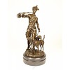 A bronze sculpture of a huntsman with horn and hounds