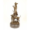 A bronze sculpture of a huntsman with horn and hounds