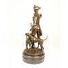 A bronze sculpture of a huntsman with horn and hounds