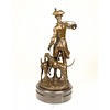 A bronze sculpture of a huntsman with horn and hounds