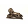 A bronze sculpture of a reclining lion (left)