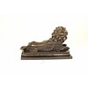 A bronze sculpture of a reclining lion (left)