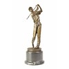 A bronze sculpture of a golfer in action