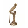 A bronze sculpture of a Macaw parrot perched on a branch