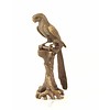 A bronze sculpture of a Macaw parrot perched on a branch