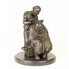 A bronze sculpture of a Chinese barber scene