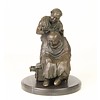 A bronze sculpture of a Chinese barber scene