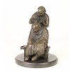 Een bronzen sculptuur van een chineze kapperscene