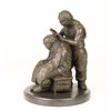 A bronze sculpture of a Chinese barber scene