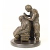 A bronze sculpture of a Chinese barber scene